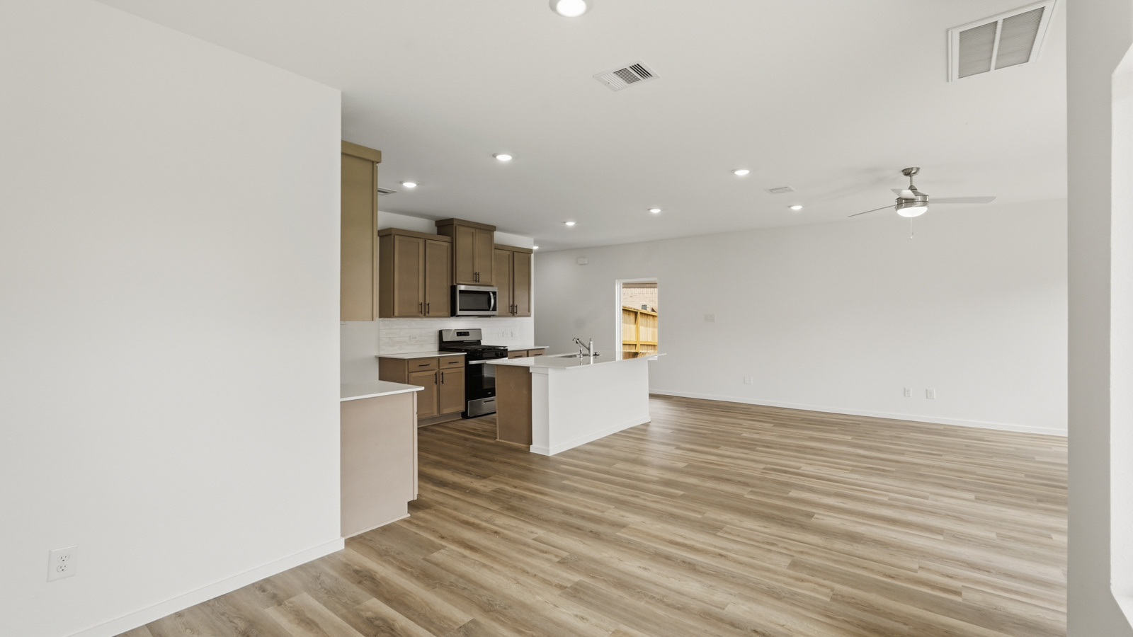 open concept living and dining area with quartz countertops, stainless steel appliances and vinyl flooring in Hockley, Tx