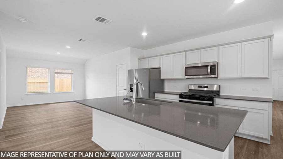 open concept living and dining area with vinyl flooring, quartz countertops, and stainless steel appliances