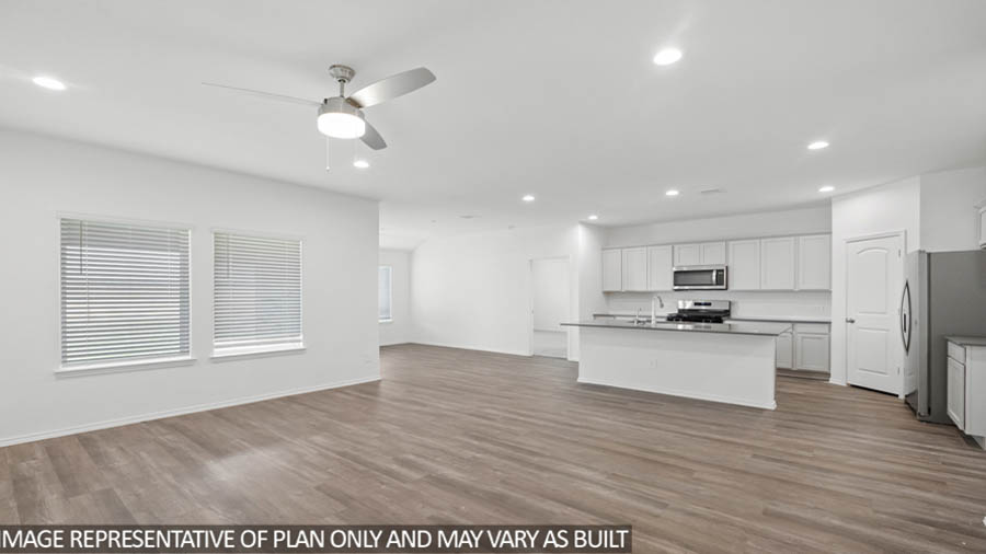 open concept living and dining area with vinyl flooring, large windows, and quartz countertops in Hockley, TX