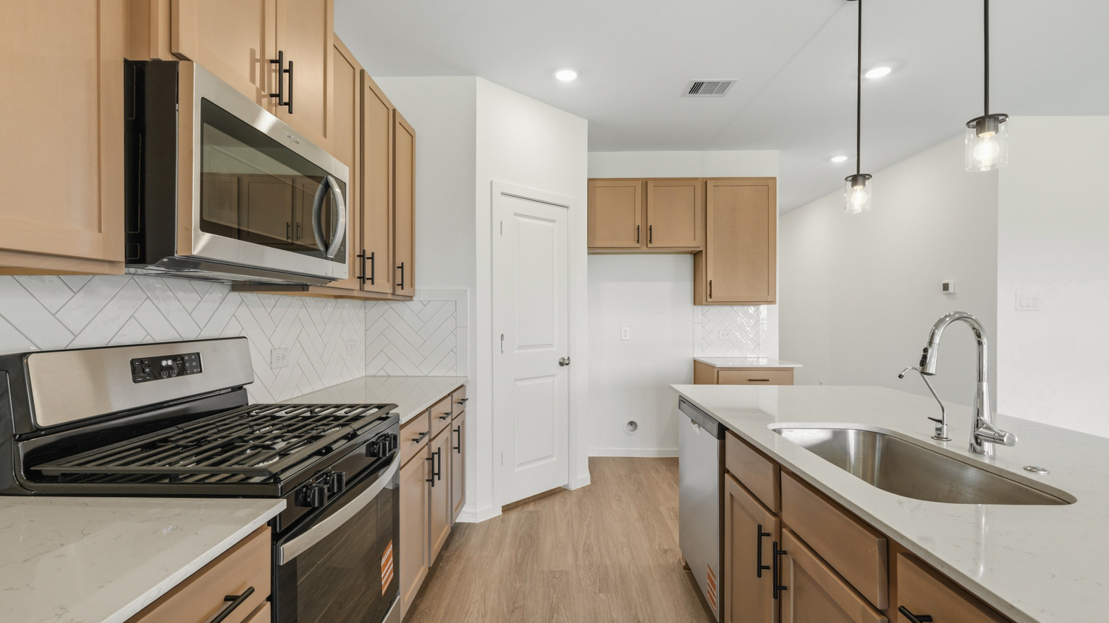open concept living and dining area with vinyl flooring, quartz countertops, and stainless steel appliances