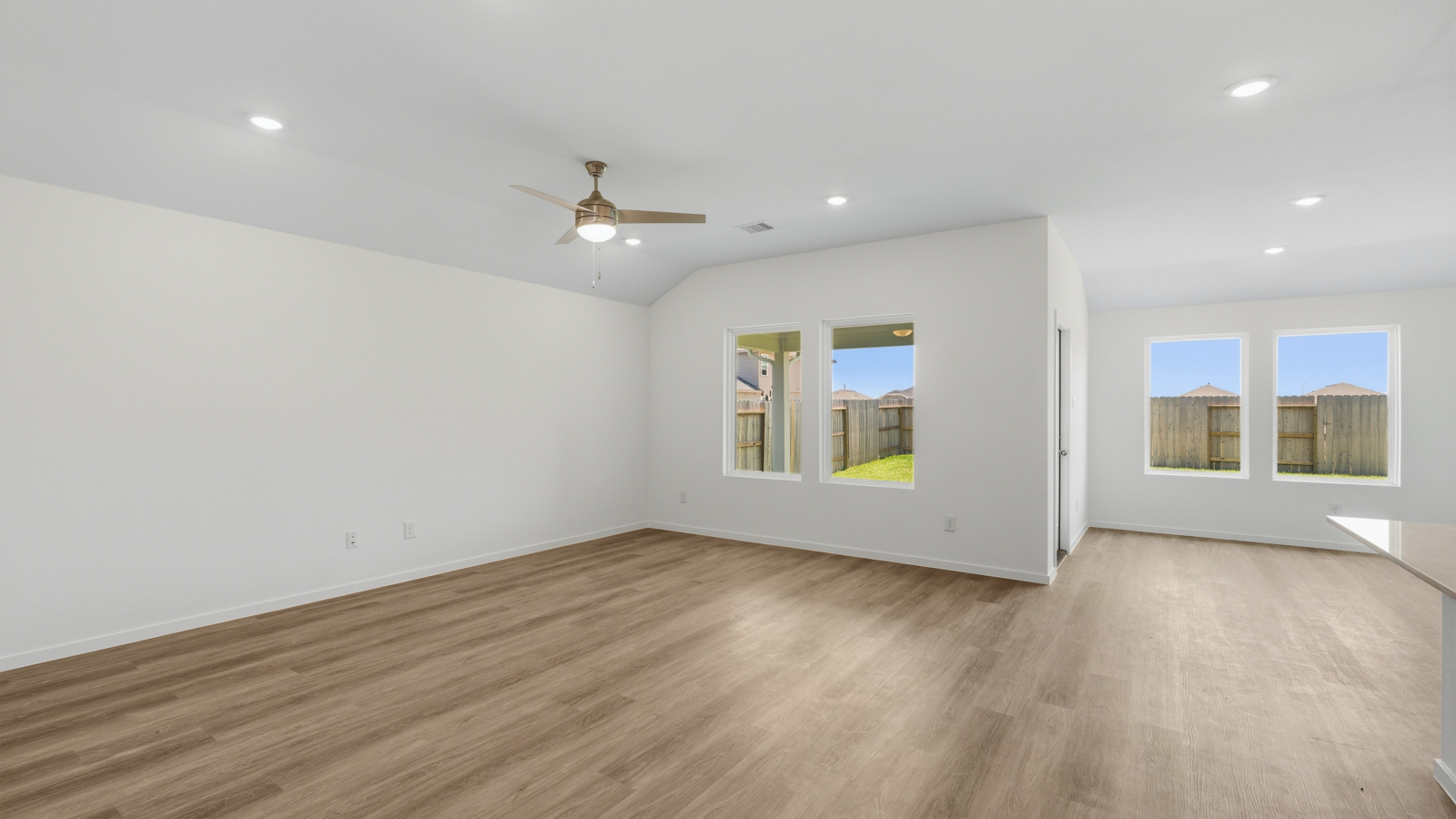 open concept living and dining area with vinyl flooring, quartz countertops, and stainless steel appliances