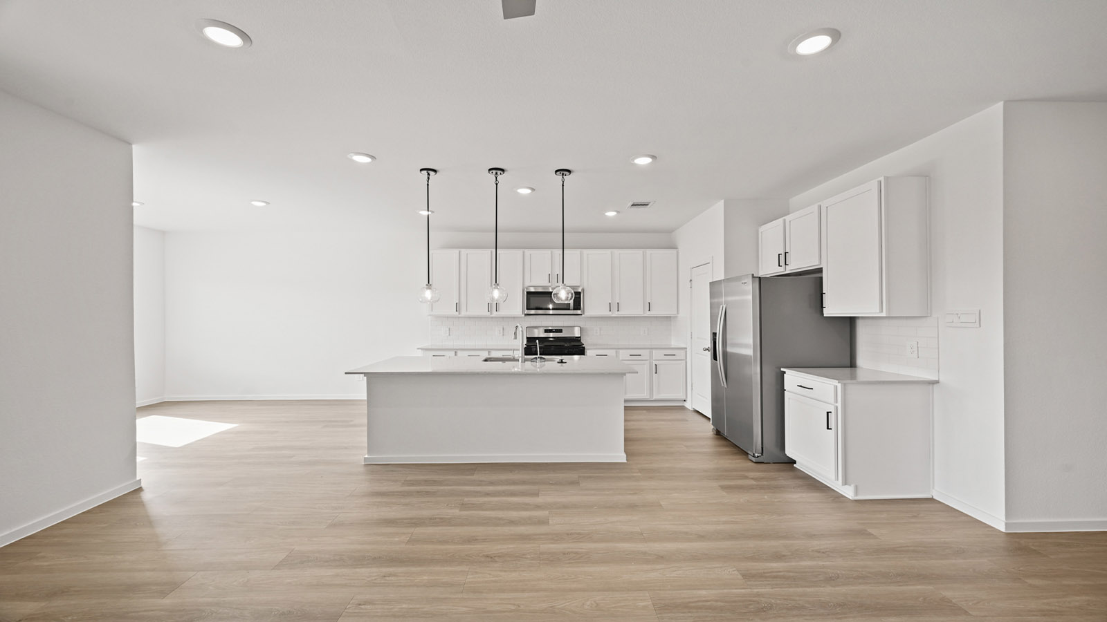 open concept living and dining area with pendant lights, quartz countertops, and large windows