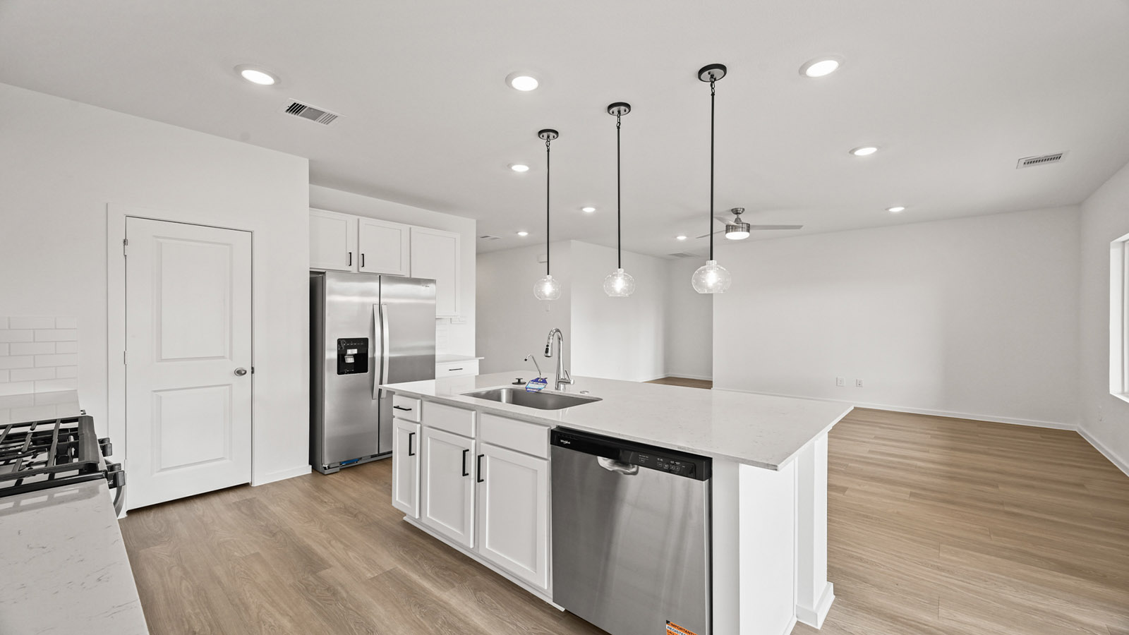 open concept living and dining area with pendant lights, quartz countertops, and large windows