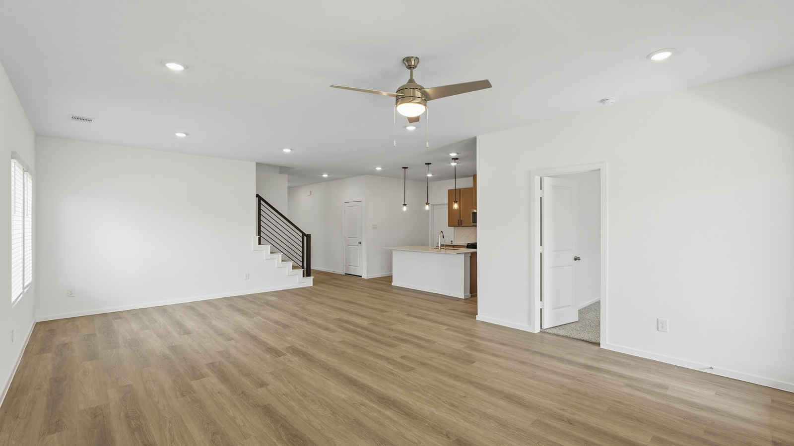open concept living and dininga rea with vinyl flooring, quartz countertops, and large windows