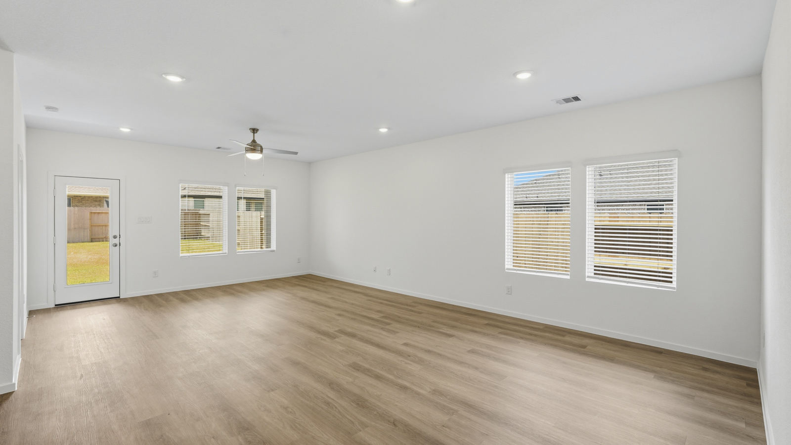 open concept living and dininga rea with vinyl flooring, quartz countertops, and large windows