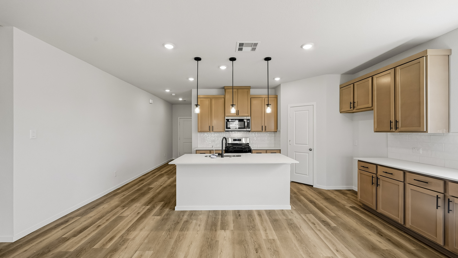 open concept living and dining area with vinyl flooring, quartz countertops, and stainless steel appliances in Hockley, TX