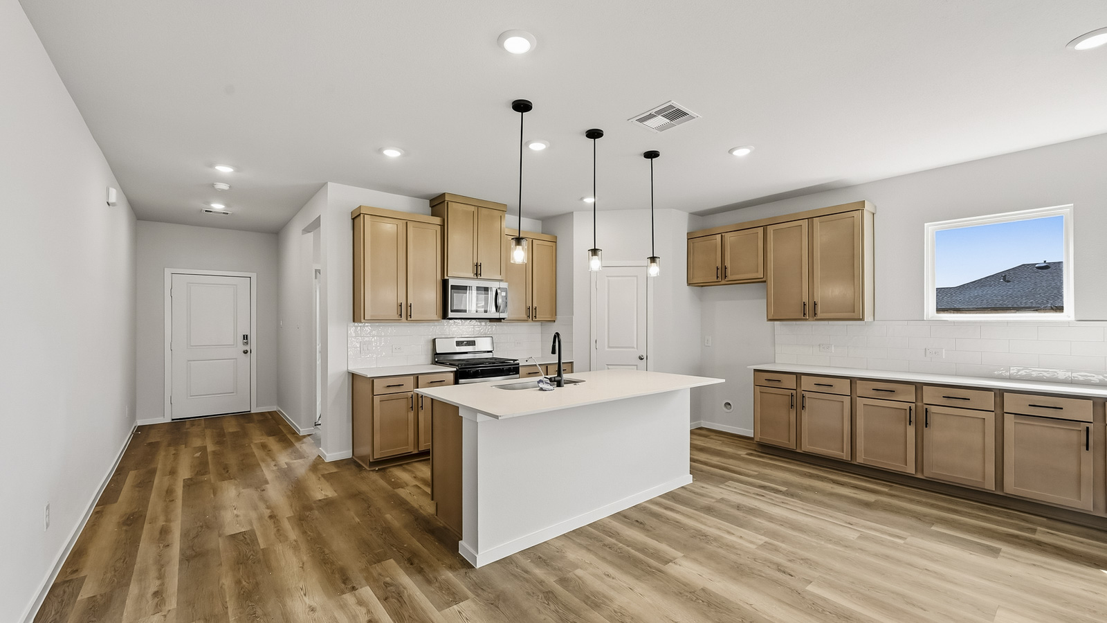 open concept living and dining area with vinyl flooring, quartz countertops, and stainless steel appliances in Hockley, TX