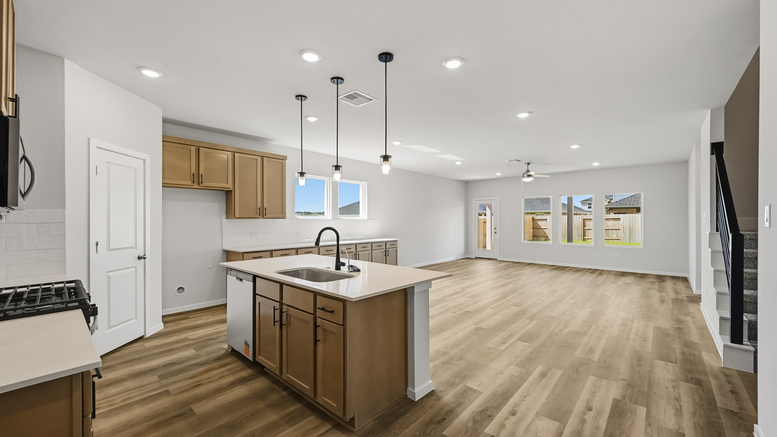 open concept living and dining area with vinyl flooring, quartz countertops, and stainless steel appliances in Hockley, TX