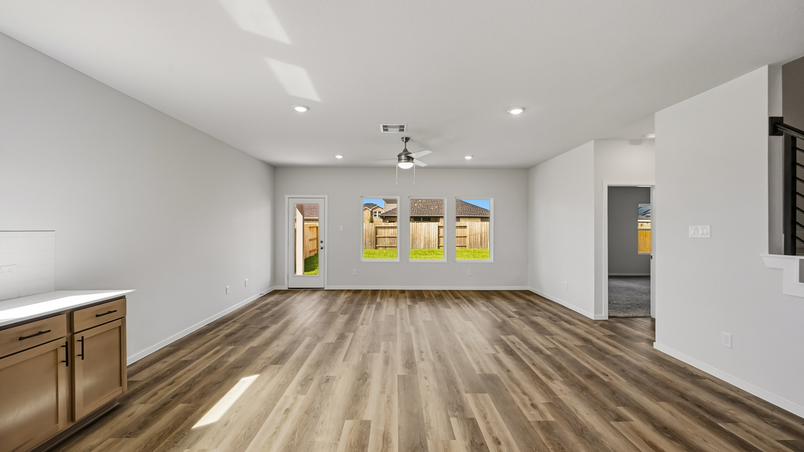 open concept living and dining area with vinyl flooring, quartz countertops, and stainless steel appliances in Hockley, TX