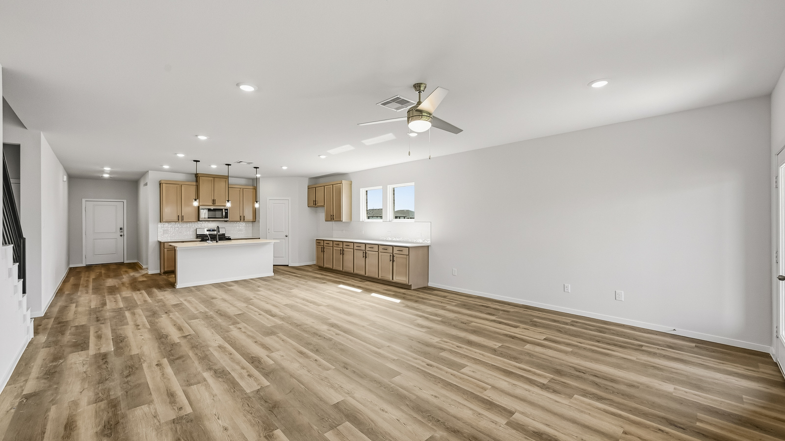 open concept living and dining area with vinyl flooring, quartz countertops, and stainless steel appliances in Hockley, TX