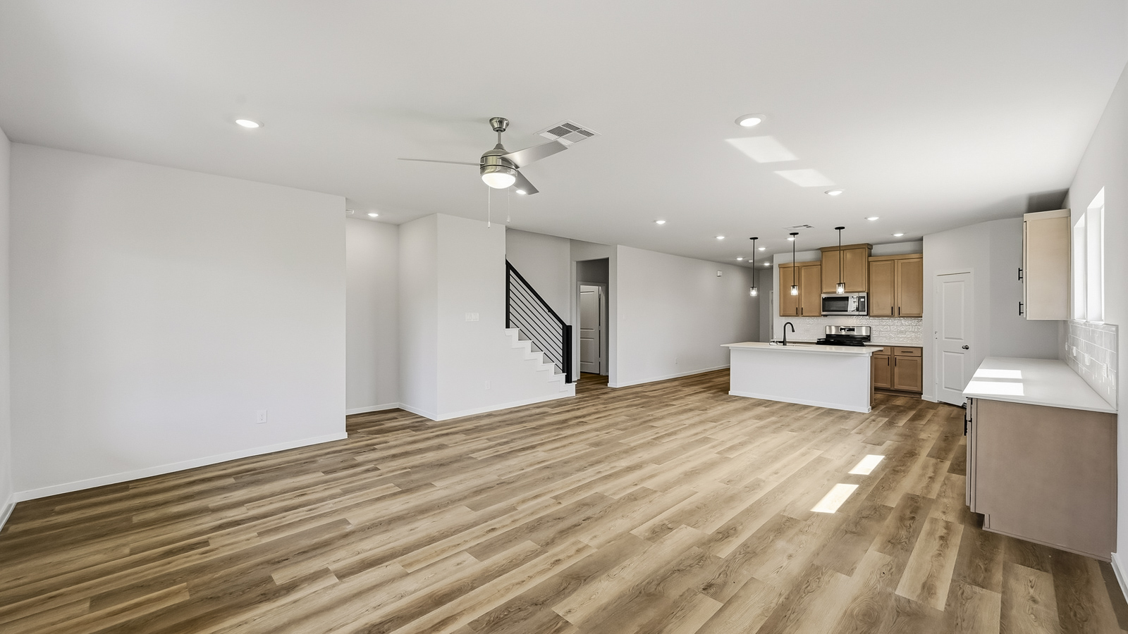 open concept living and dining area with vinyl flooring, quartz countertops, and stainless steel appliances in Hockley, TX