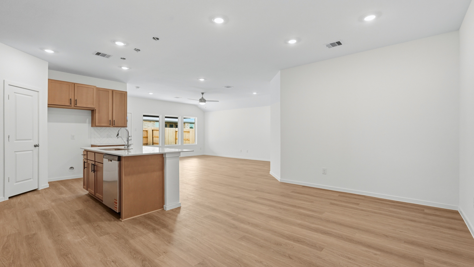 open concept living and dining area with vinyl flooring, quartz countertops, and large windows