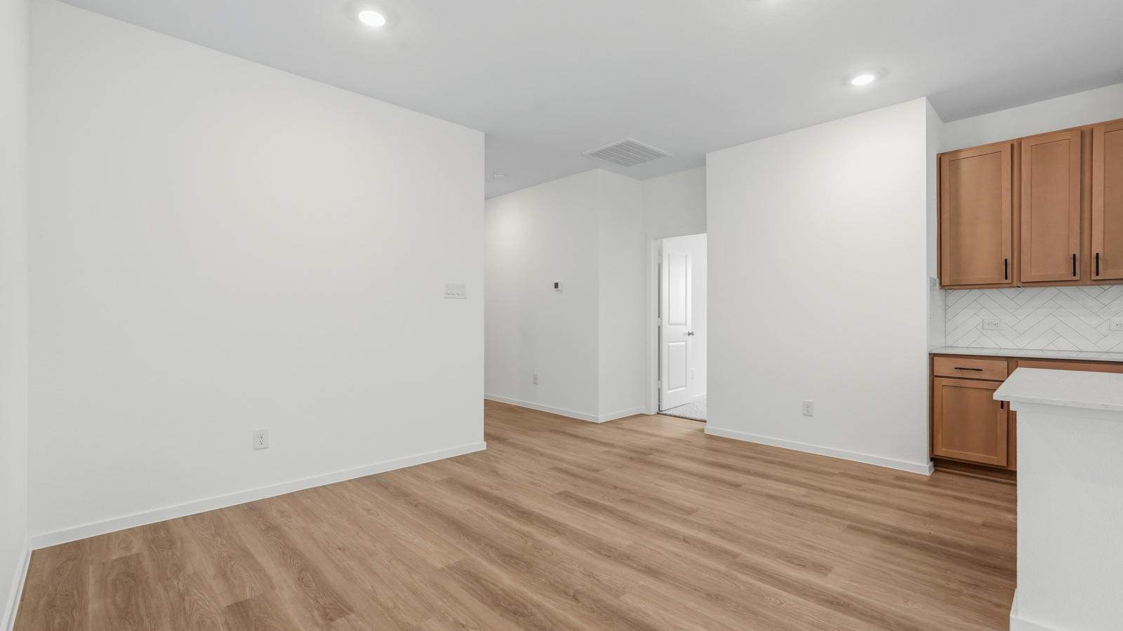 open concept living and dining area with vinyl flooring, quartz countertops, and large windows