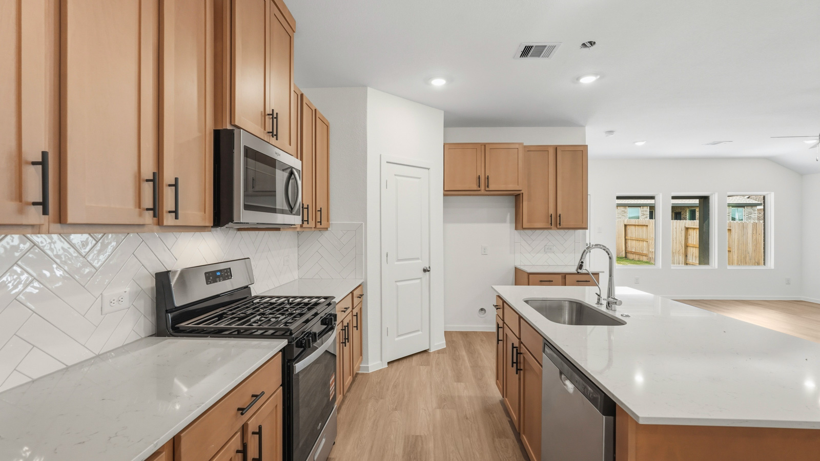 open concept living and dining area with vinyl flooring, quartz countertops, and large windows