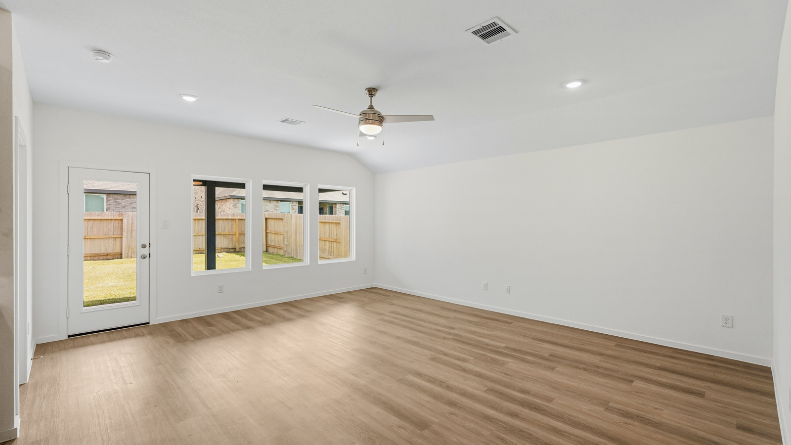 open concept living and dining area with vinyl flooring, quartz countertops, and large windows