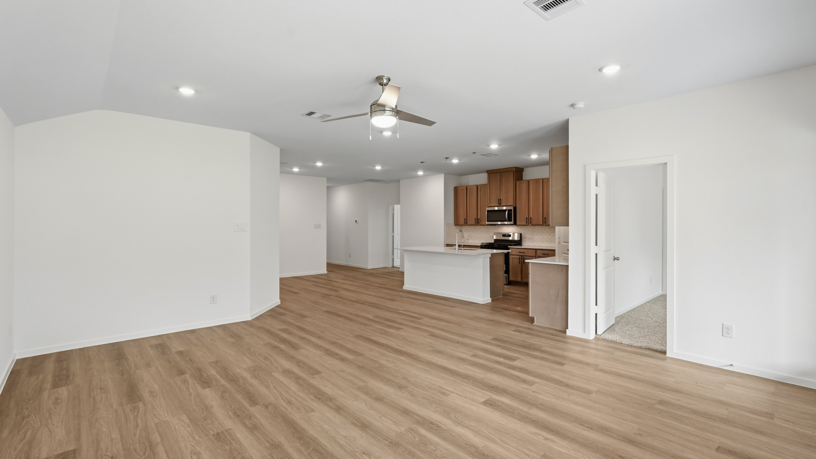 open concept living and dining area with vinyl flooring, quartz countertops, and large windows