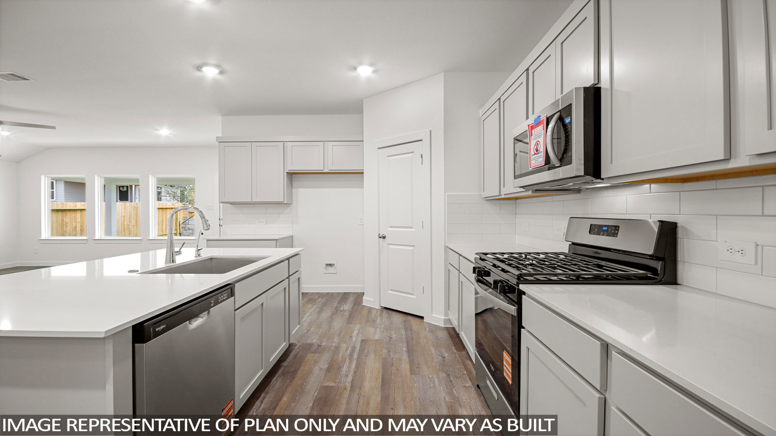 open concept livivng and dining area with vinyl flooring, quartz countertops, and large windows