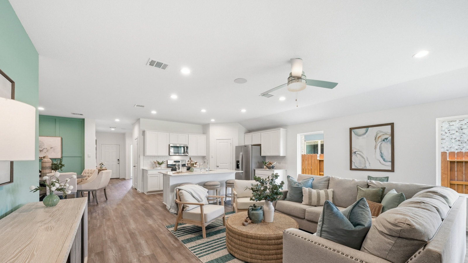 open concept living and dining area with Mohawk flooring and large windows