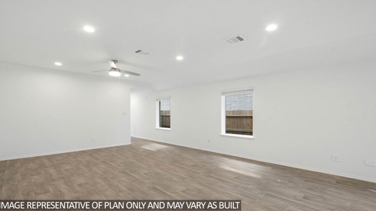 Primary bedroom with windows, white walls, and light carpet.