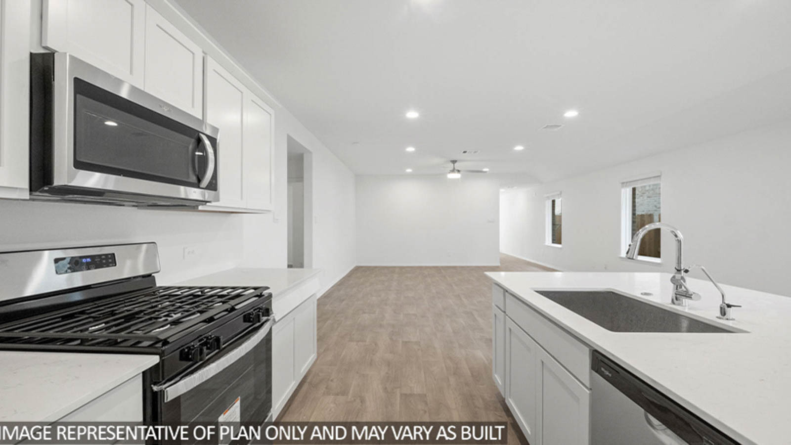 Open kitchen with an island, stainless steel appliances, white walls, white cabinets, and vinyl wood flooring.
