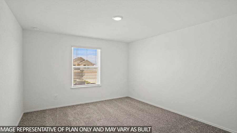 Secondary bedroom with white walls, windows, and light carpet.