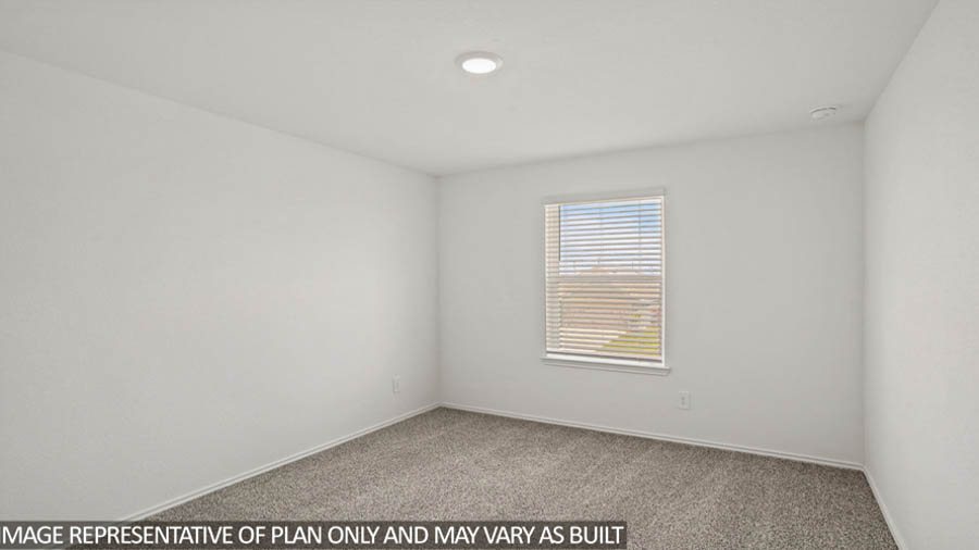 Secondary bedroom with white walls, windows, and light carpet.
