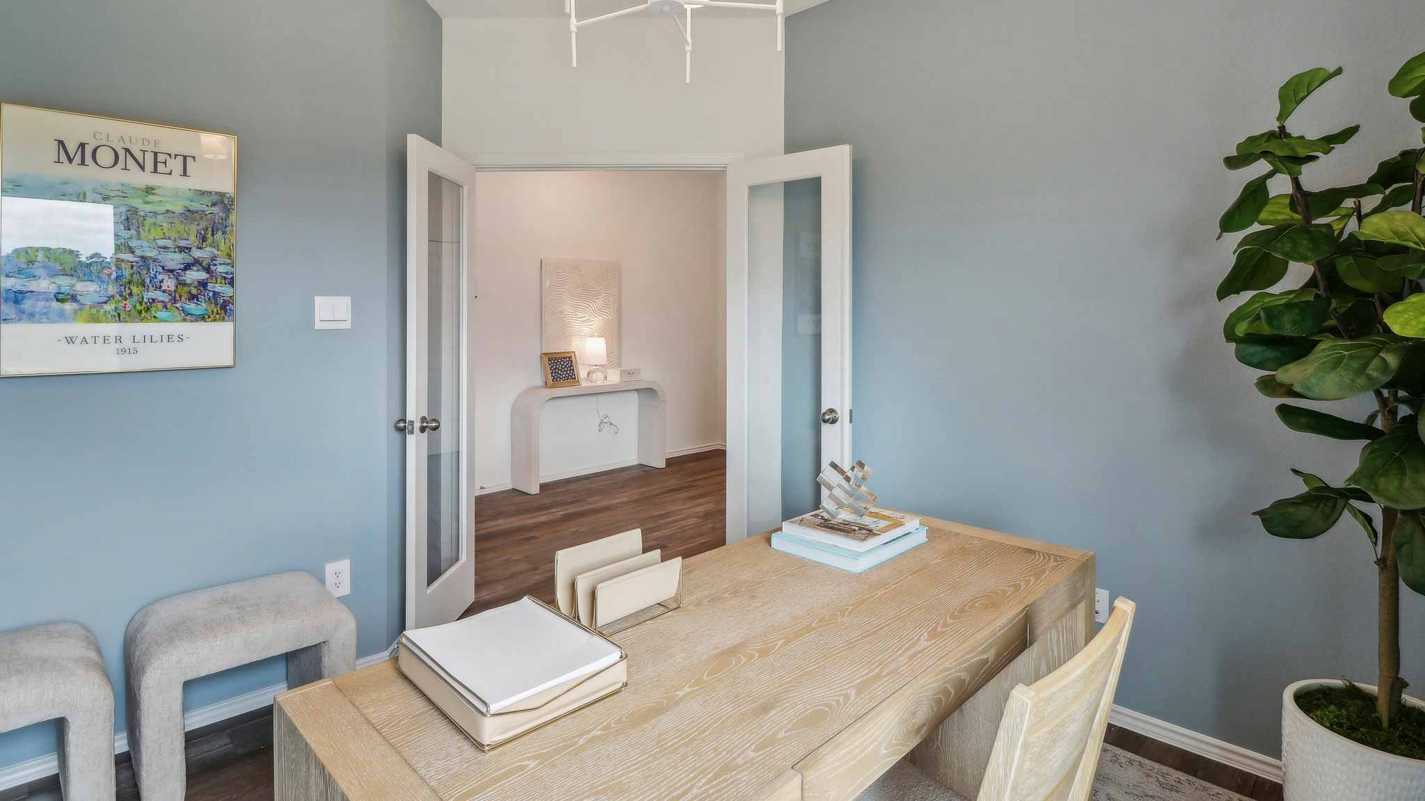 Study with windows, white walls, and vinyl wood flooring.