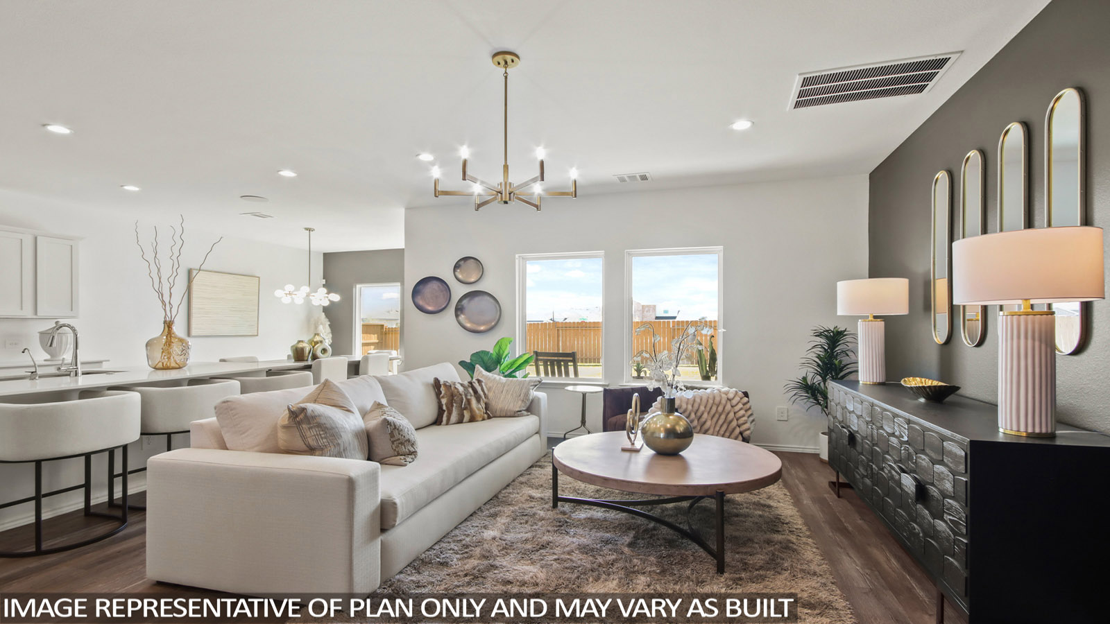 Spacious living area with brown flooring, a white couch and large windows.