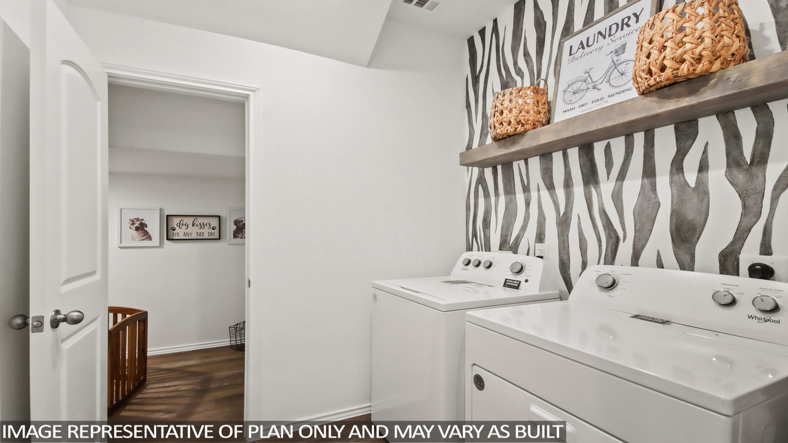 Laundry room featuring an accent wall and appliances.