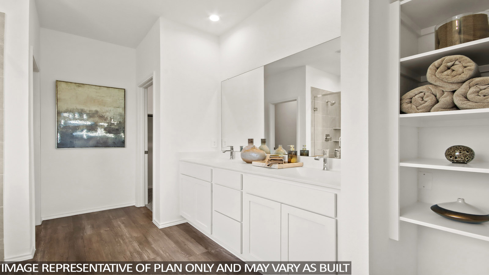 Bathroom with a dual sink, white cabinets, and a large mirror above.