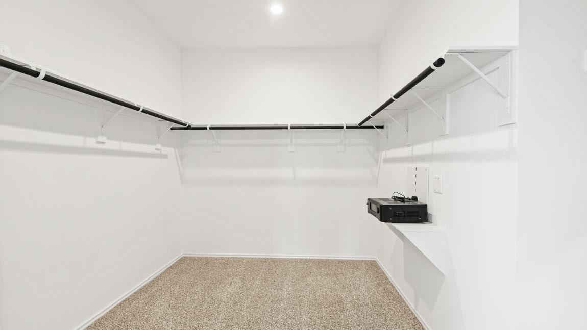Walk in closet with a hanging rod.