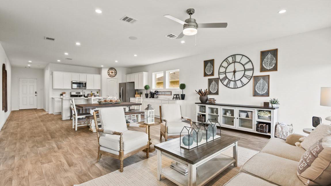 Living area featuring a white couch, two chairs, and a coffee table.
