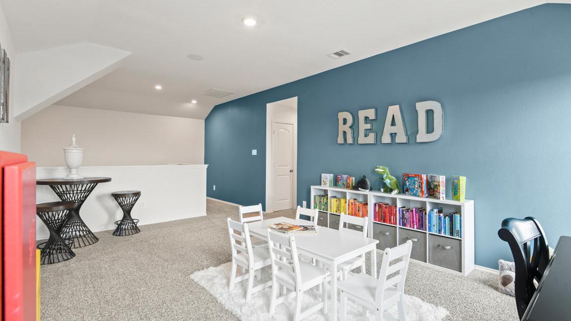 Large room with a small table and a bookshelf.