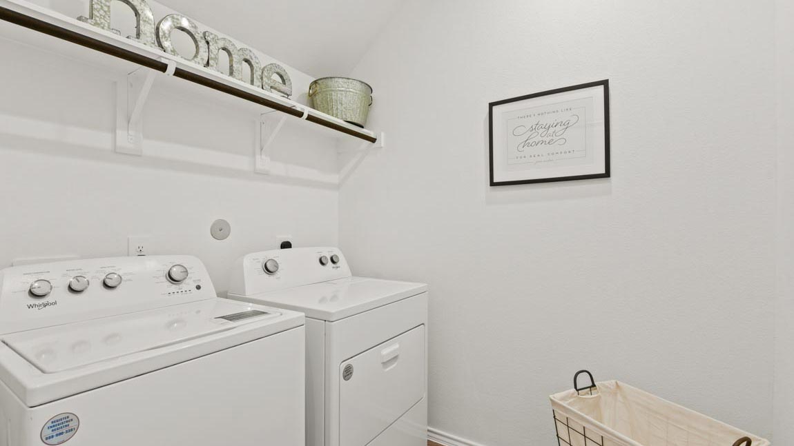 Laundry room with a hanging rod above appliances.