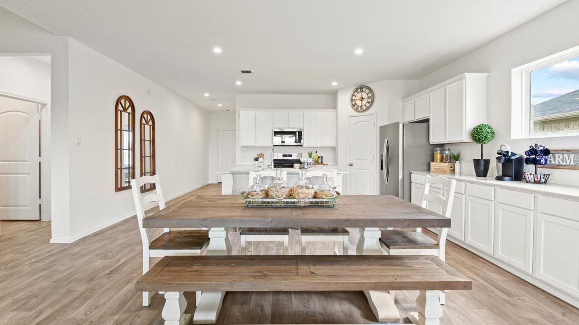 Dining area connecting to kitchen with a large brown table.