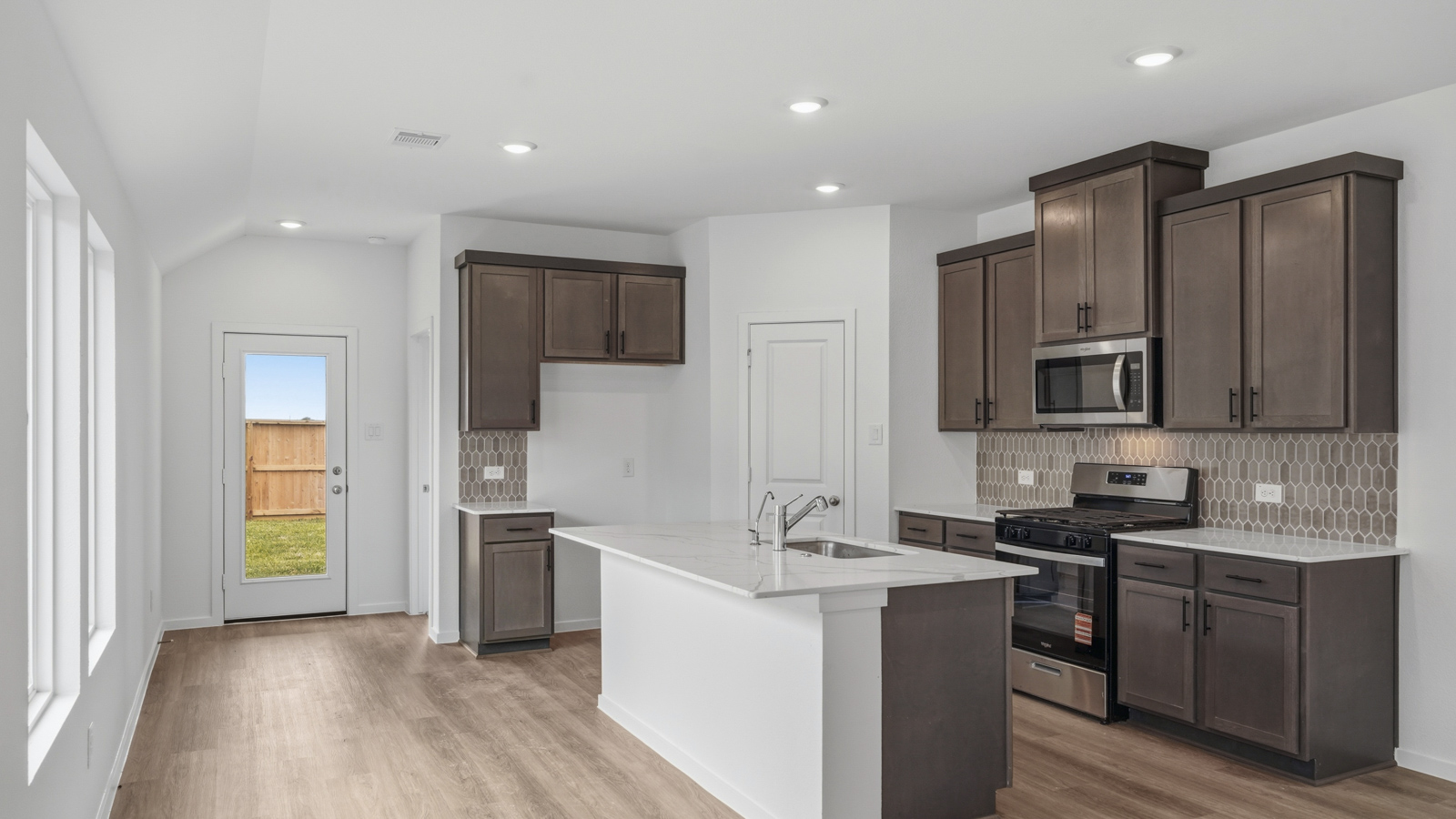 open concept living and dining area with backsplash, quartz countertops, and stainless steel appliances