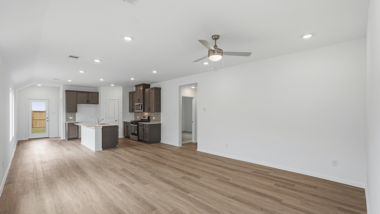 open concept living and dining area with backsplash, quartz countertops, and stainless steel appliances