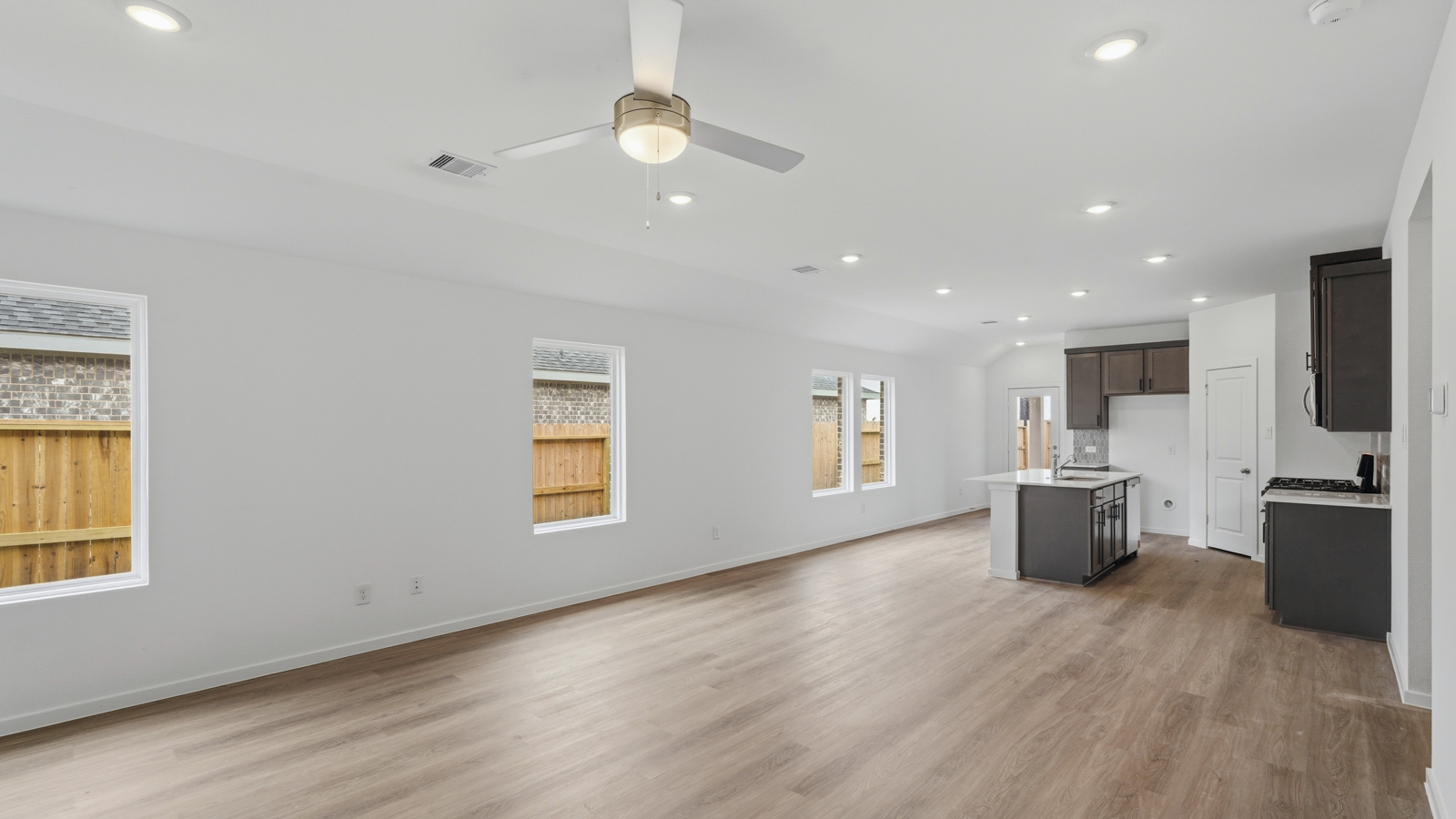 open concept living and dining area with backsplash, quartz countertops, and stainless steel appliances