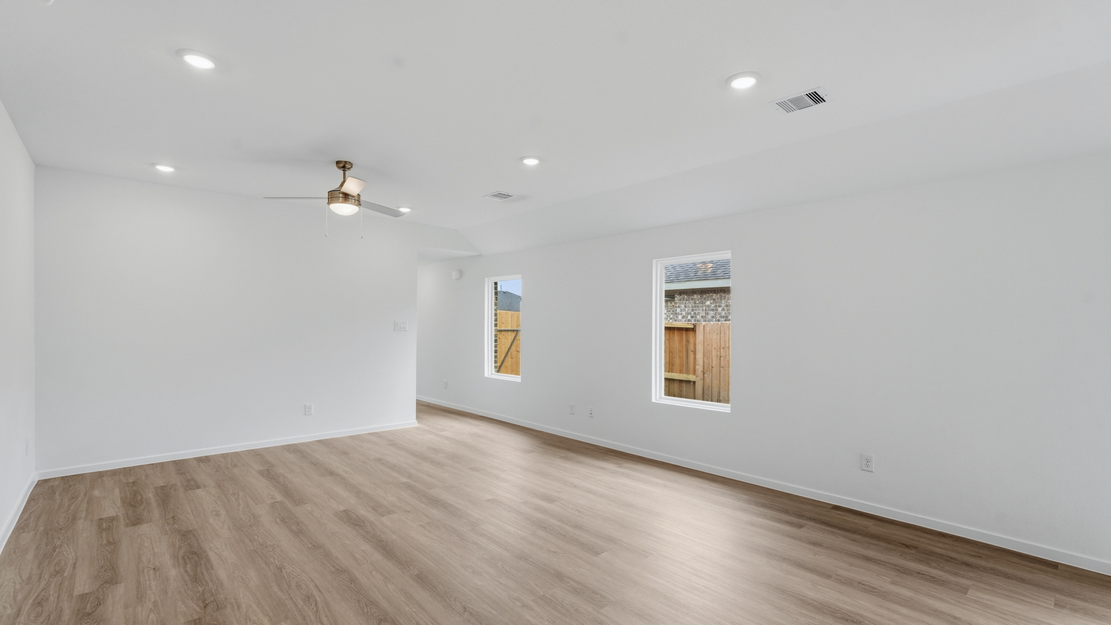 open concept living and dining area with backsplash, quartz countertops, and stainless steel appliances