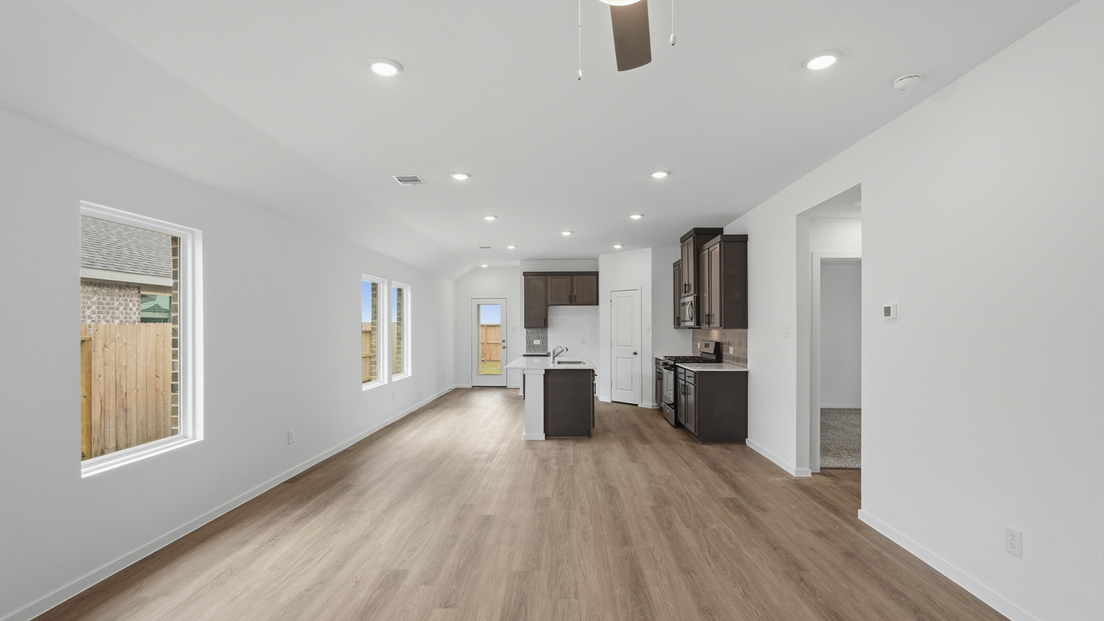 open concept living and dining area with backsplash, quartz countertops, and stainless steel appliances