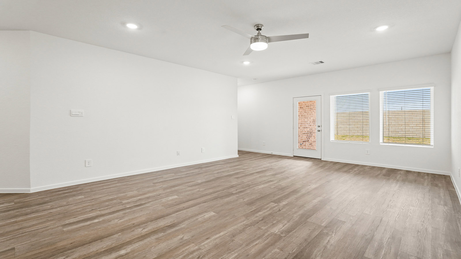 open concept living and dining area with vinyl flooring, quartz countertops, and large windows
