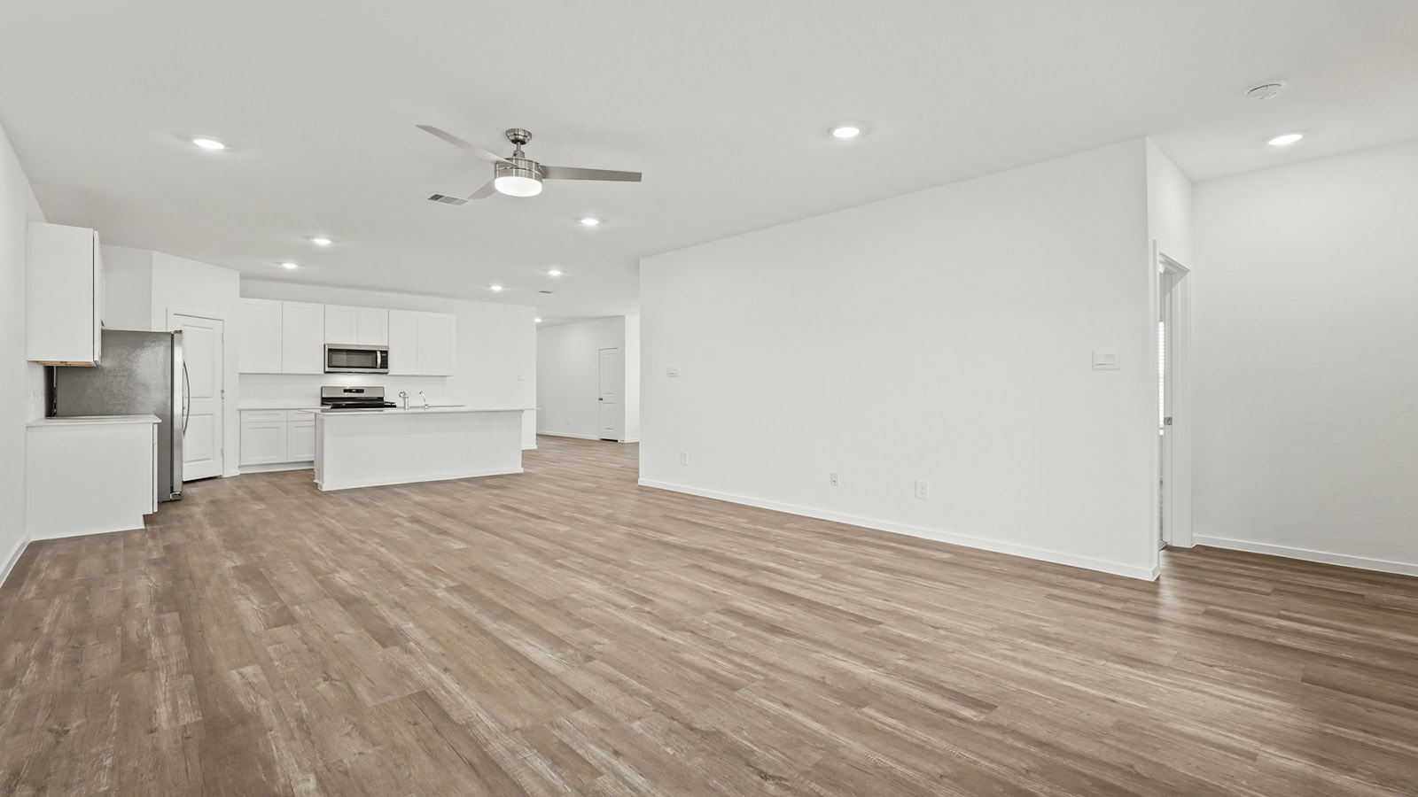 open concept living and dining area with vinyl flooring, quartz countertops, and large windows