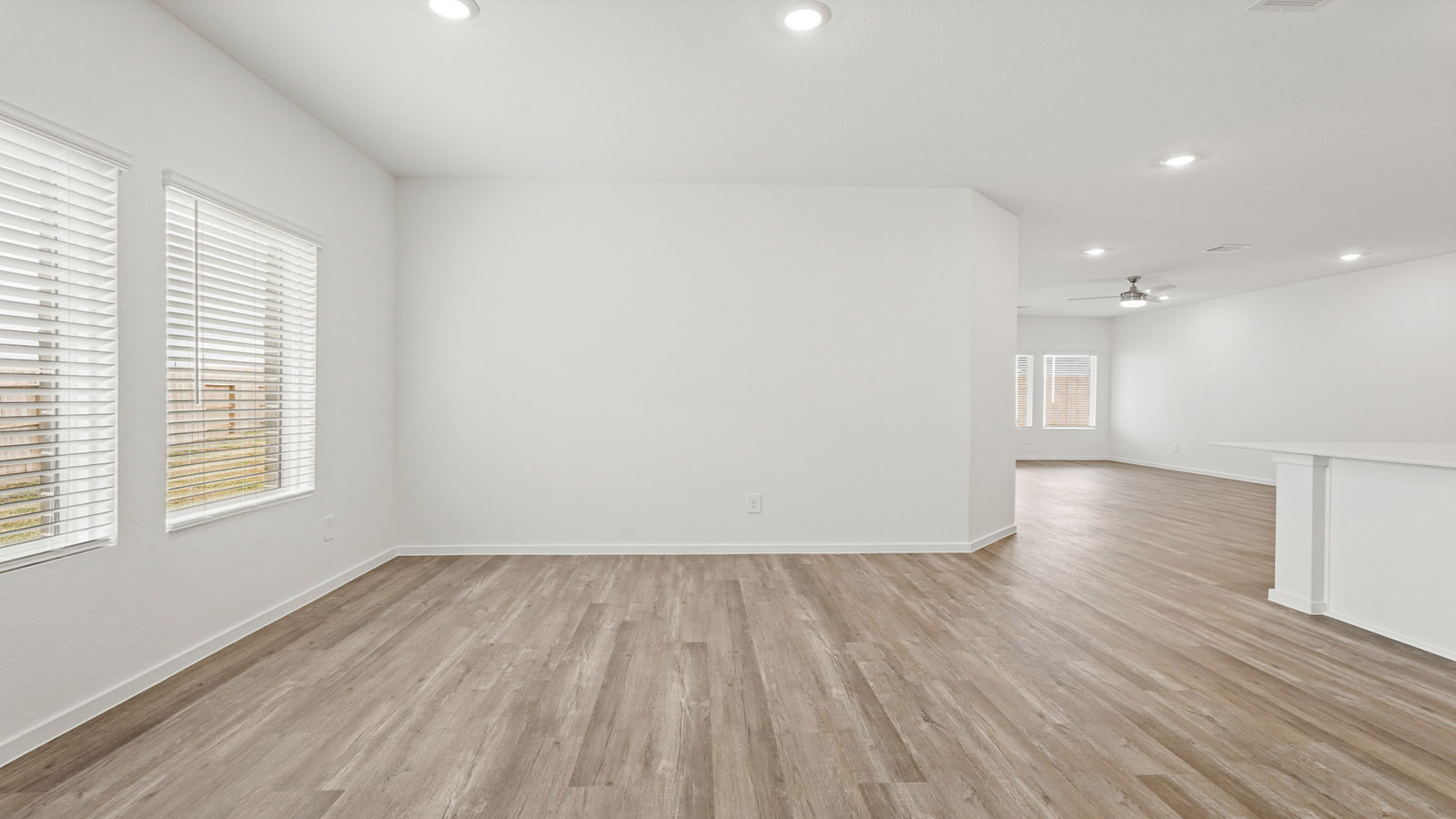 open concept living and dining area with vinyl flooring, quartz countertops, and large windows