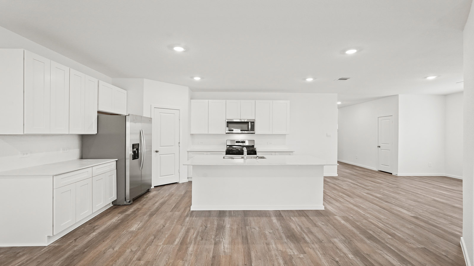 open concept living and dining area with vinyl flooring, quartz countertops, and large windows