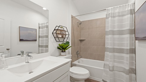 Secondary bathroom with a shower and tub combo, white walls, and vinyl wood flooring.
