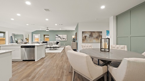 Open living room with windows, white walls, and vinyl wood flooring.