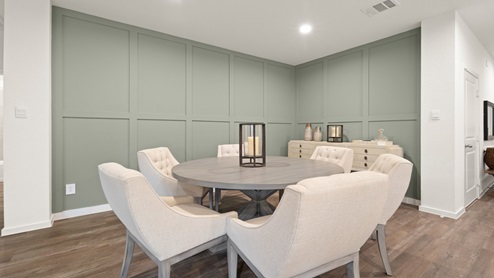 Open living room with windows, white walls, and vinyl wood flooring.