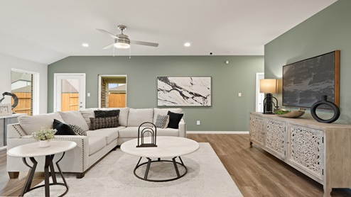 Open living room with windows, white walls, and vinyl wood flooring.