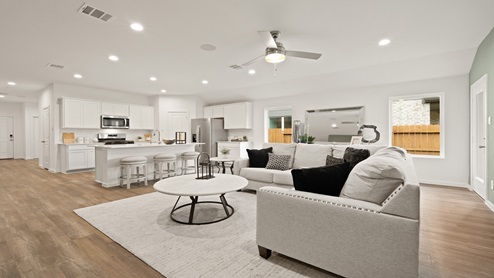 Open living room with windows, white walls, and vinyl wood flooring.