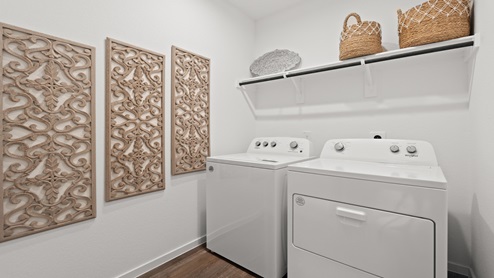 Laundry room with white walls and vinyl wood flooring.